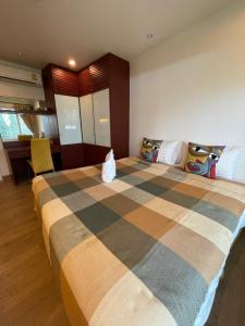 Un dormitorio con una cama grande con una manta a rayas. en My Mykonos มายมิโคนอส, en Hua Hin 50 fotos más