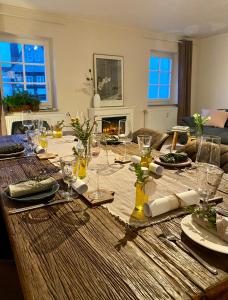 a wooden table with plates and wine glasses on it at Ferienwohnung Lieselotte in Diez