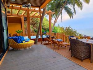 a wooden deck with a table and chairs on it at Cola Goa Beach Resort in Cola