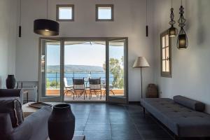 a living room with a couch and a view of the ocean at Jasmine by the sea - Κάτω Γατζέα, Πήλιο in Kato Gatzea