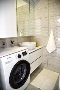 a washing machine in a bathroom with a sink at La Luna Premium Deluxe Apartment with Free Jacuzzi, Bikes & Covered Parking in Našice