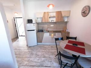 a kitchen with a table and chairs and a refrigerator at Rimimi Apartamente Studio in Mamaia Nord