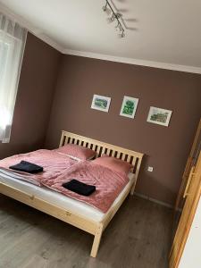 Schlafzimmer mit einem Bett mit rosafarbener Bettdecke in der Unterkunft Csuszka vendégház in Tiszafüred