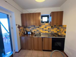 a small kitchen with wooden cabinets and a sink at APARTMENT LUKA Novalja in Novalja