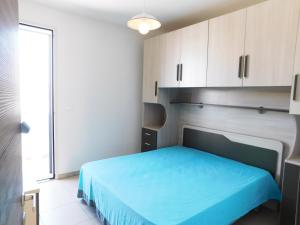 トッレ・サン・ジョヴァンニ・ウジェントにあるActon Apartment Torre San Giovanni - Verso Sudのベッドルーム(青いベッド1台、白いキャビネット付)