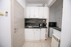 a small kitchen with white cabinets and a sink at Paradise Apartment in Sandanski