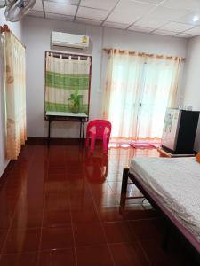 Habitación con cama, mesa y silla rosa. en TAMONWAN HOUSE Koh Tao en Ko Tao