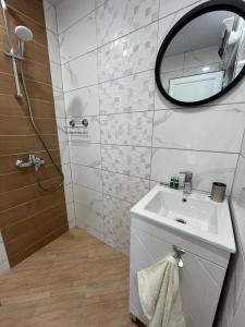 uma casa de banho com um lavatório e um espelho em Prista guest rooms em Ruse