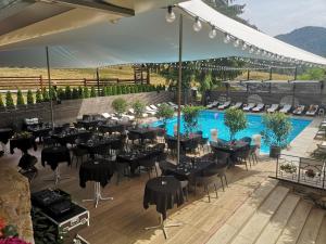 a restaurant with tables and chairs next to a pool at Pensiunea Mai in Răşinari