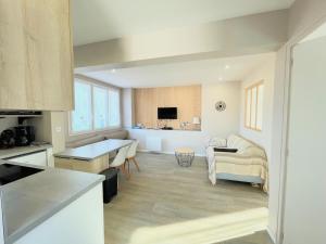 a kitchen and living room with a table and a couch at Gîte Le Plessis Océan à 200m de la mer, parking privé et jardin clos in Pornic