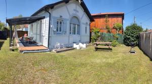 a small house in a yard with a picnic table at Villa Primerose in Andernos-les-Bains