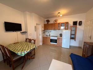 uma cozinha com uma mesa e um frigorífico branco em APARTMENT ADRIAN NOVALJA em Novalja