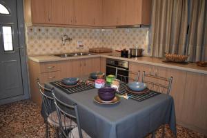 eine Küche mit einem Tisch mit Schalen und Geschirr darauf in der Unterkunft Rose's House in Tríkala