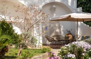 patio con ombrellone, tavolo e sedie di B&B Il Sogno ad Anacapri