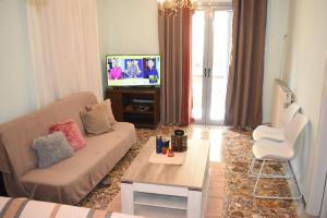 salon z kanapą i telewizorem w obiekcie Rose's House w mieście Tríkala