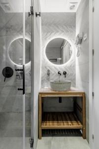 Marco Polo Residence Hostal Boutique في مدريد: حمام مع حوض ومرآة