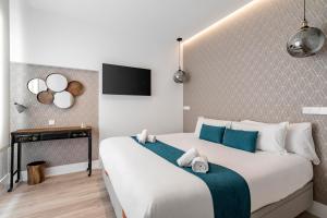 a bedroom with a large white bed with blue accents at Marco Polo Residence Hostal Boutique in Madrid