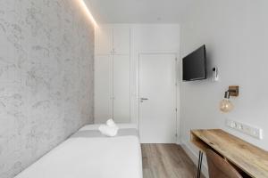 een slaapkamer met een bed en een tv aan de muur bij Marco Polo Residence Hostal Boutique in Madrid