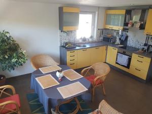 cocina con mesa, sillas y armarios amarillos en Zimmer 1 nahe Thoraxklinik - Bad und Küche geteilt, en Heidelberg