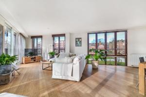 a living room with white furniture and large windows at 170M2 Appartment with Jacuzzi & Steam bath in center of Amsterdam in Amsterdam