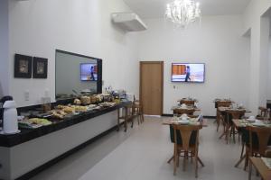 a buffet line with food on display in a restaurant at Pratti Hotel in Linhares