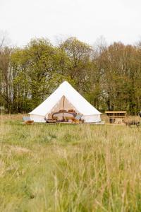 a white tent in a field of grass at Home Farm Glamping in Elstree