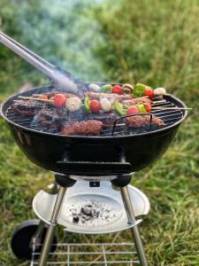 a grill with meat and vegetables cooking on it at Home Farm Glamping in Elstree