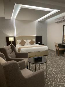 une chambre d'hôtel avec un lit, un canapé et des chaises dans l'établissement Gold Inn Hotel, à Riyad