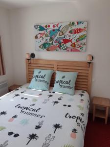 een slaapkamer met een bed met 2 kussens erop bij appartement bord de mer in Fouesnant