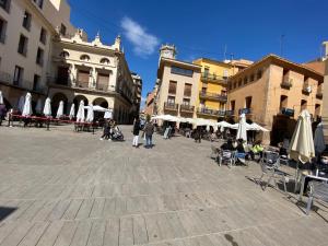 una plaza de la ciudad con gente sentada en sillas y sombrillas en PALM LIFE APARTMENT- Free Parking en Villarreal