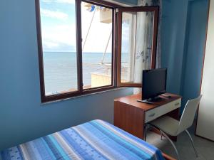 a bedroom with a desk with a computer and a window at Sea view apartment/beach/city center/WiFi in Durrës