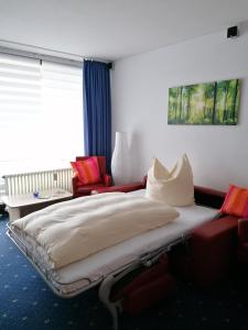 1 dormitorio con cama, sofá y ventana en Kranichsee-Apartment, en Goslar