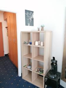 un estante de libros blanco en una habitación en Kranichsee-Apartment, en Goslar