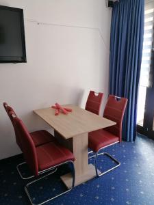 una mesa y cuatro sillas rojas en una habitación en Kranichsee-Apartment, en Goslar