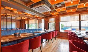 una sala da pranzo con tavoli e sedie rosse di Treebo Trend Sky Point a Siliguri