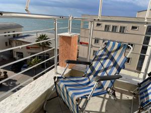 une chaise assise sur un balcon avec vue sur l'océan dans l'établissement Sea view apartment/beach/city center/WiFi, à Durrës
