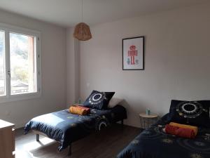 a bedroom with two beds and a window at GÎTE L'ERMITAGE CAHORS in Cahors
