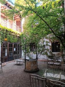 einen Innenhof mit Tischen, Stühlen und einem Baum in der Unterkunft Hosteria Real de Zamora in Zamora