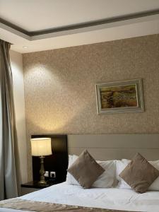 - une chambre avec un lit et une peinture murale dans l'établissement Gold Inn Hotel, à Riyad