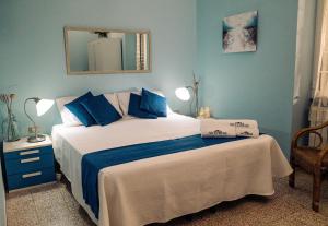 1 dormitorio con 1 cama con paredes azules y espejo en Villa Irene Pisticci-Matera, en Pisticci