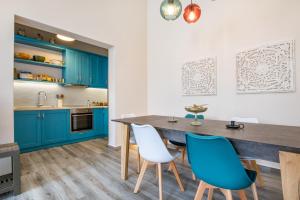 a kitchen with blue cabinets and a wooden table and chairs at Annika's Family House in Karpathos