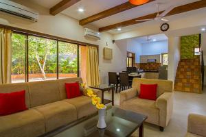 a living room with a couch and a table at StayVista's B-22 Autumn with Private Pool & Terrace in Vāda
