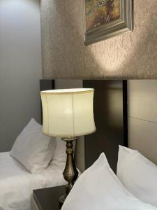 فندق قولد ان في الرياض: وجود مصباح على طاولة بجانب سريرين
