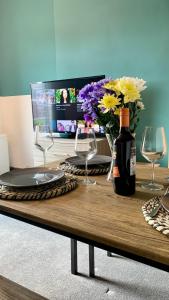 a table with glasses and a bottle of wine and flowers at Apartment in City centre, 4 guests, CAR PARK in Doncaster