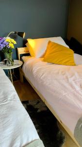 ein Bett mit einem gelben Kissen und einem Tisch mit Blumen in der Unterkunft Apartment in City centre, 4 guests, CAR PARK in Doncaster