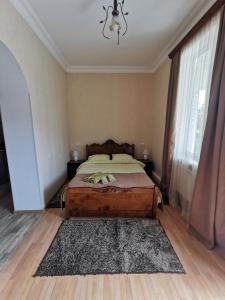 a bedroom with a bed and a chandelier at Grimis Villa in Borjomi