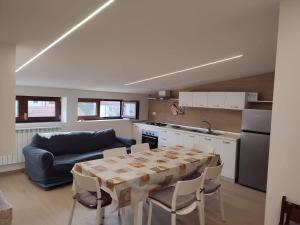 uma cozinha com uma mesa e um sofá azul em Residenze Macerelli em Roccaraso