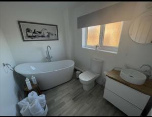 a bathroom with a tub and a toilet and a sink at A beautiful house in a scenic town location. in Louth