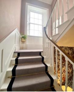 
a stairway leading up to a large room at The Stables Townhouse B&B in Birr
