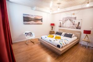 1 dormitorio con 1 cama y una pintura en la pared en Appt Ambiance bohème 2 ch Piscine lagon en Tarbes